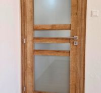 Interior doors with wood decor and frosted glass in a 3-room apartment.