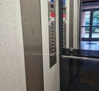 The interior of an elevator with a stainless steel button panel in a 3-room apartment.
