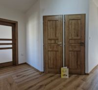 Interior of a 3-room apartment with a wooden decor floor and wooden doors.