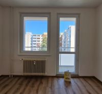 A room in a 3-room apartment with a wooden decor floor and a glass view of the surroundings.