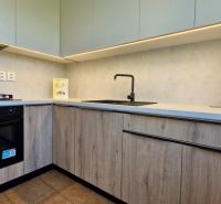 A kitchen in a 3-room apartment with a wooden decor floor and modern equipment.