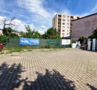 Parking lot on Piešťanská Street in Nové Mesto nad Váhom, surrounded by buildings and greenery.