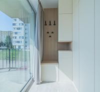 A bright hallway with a glass wall, hooks, and storage space in a 4-room apartment.