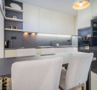 A kitchen in a 4-room apartment with a dining table and a wooden decor floor.