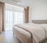 Bright bedroom in a 4-room apartment with large windows and a bed.