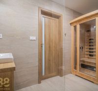 Bathroom with a sauna in a 4-room apartment with wooden decor and a sink.