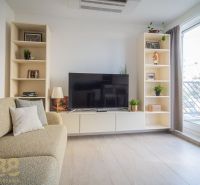 Living room with a television, sofa, and shelves in a 4-room apartment, floor with wooden decor.