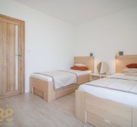 A bright bedroom in a 4-room apartment with two single beds and wooden decor.
