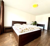 A bedroom with wooden furniture and a wooden decor floor in a studio apartment.