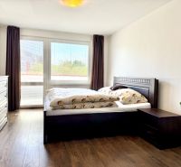 Bedroom with a bed and a dresser, wooden decor flooring, in a studio apartment.