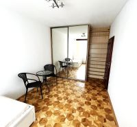 Bedroom with wood-patterned flooring in a 3-room apartment; bed, wardrobe, table, chairs.