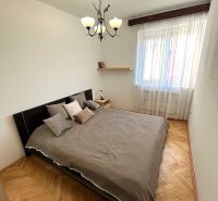 Bedroom with a bed and chandeliers, floors with wood decor in a 3-room apartment.