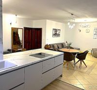 Kitchen and living room in a 3-room apartment with a kitchen counter and dining table.
