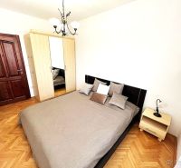 A bedroom in a 3-room apartment with a bed, a wardrobe, and a floor with a wooden decor.