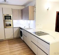 A kitchen in a 3-room apartment with white cabinets and a wooden decor floor.