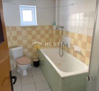 Bathroom with a bathtub and toilet in a family house, with tiled decoration.