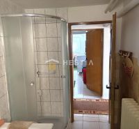 A bathroom in a family house with tiles and a shower corner.