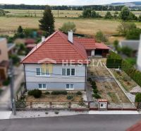 A family house in Šajdíkové Humence with a red roof and a landscaped garden.