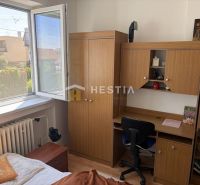 A room in a family house with a desk, a wardrobe, and a view from the window.