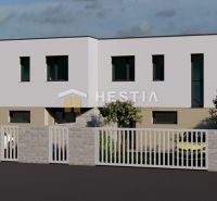 A two-story building with trees and a fence in Rovensko.