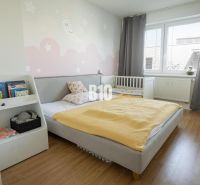 Children's room with a bed, crib, wooden decor flooring, and a bookshelf in a 3-room apartment.
