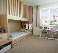 A children's room in a 3-room apartment with a bunk bed, a desk, and carpeted flooring.