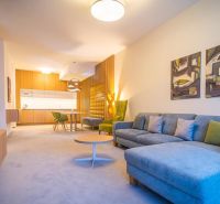 Living room in a holiday apartment with a comfortable sofa and a wooden decor floor.