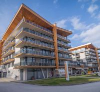The building of the Recreational Apartment in Starý Smokovec with glass balconies and wooden decor.