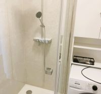 A bathroom in a 3-room apartment with a shower and a washing machine.