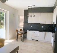 A bright kitchen with a wood-patterned floor in a 3-room apartment.