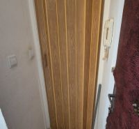 A hidden space with sliding doors and a wooden decor floor in a studio apartment.