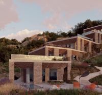 Villas in Dhërmi on a slope surrounded by greenery and rocks under a blue sky.