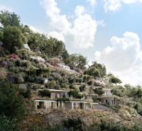 Villas in Dhërmi nestled in the hillside, surrounded by lush vegetation and blue skies.