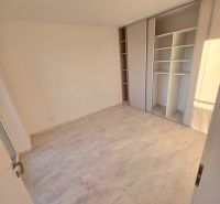 A room with a wooden decor floor and a built-in wardrobe in a 2-room apartment.