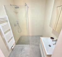 Bathroom with an open shower in a 2-room apartment with an elegant floor.