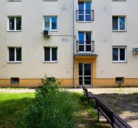 Apartment building with benches and greenery on Herlianska Street in Bratislava-Ružinov.