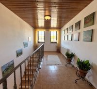 A hallway with decorations and flowers, a floor with a wooden decor, a family house.