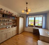 A room in a family house with shelves full of decorations and a floor with a wooden decor.