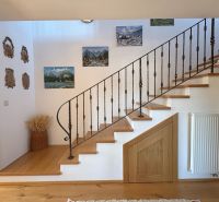 Interior of a family house with a wooden staircase and wall decorations.