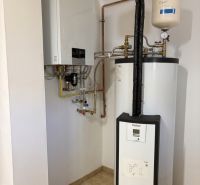 Boilers with piping in a family house, on a floor with ceramic tiles.