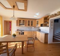A kitchen in a family house with wooden cabinets and a floor with a wooden decor.
