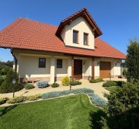 A family house in Trenčianska Turná with a red roof and a landscaped garden.