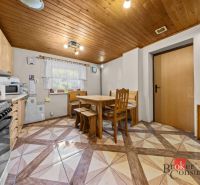 A kitchen in a family house with wooden paneling on the ceiling and a table for four.