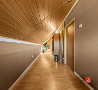 A hallway in a family house with a wooden decor floor and a slanted ceiling.