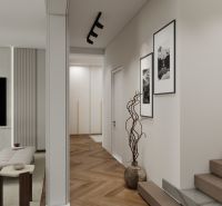Interior of a family house with a wood-decorated floor, stairs, and art paintings.