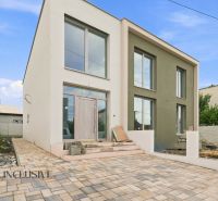 A family house in Holice with a light facade and a paved courtyard.
