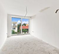 An empty room with a view from the window in a family house, without flooring.