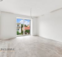 A room in a family house with an unfinished floor, a large window, and a view of the gardens.