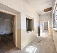 The interior of a family house with peeling walls, light streaming through the windows.