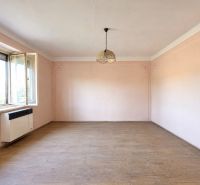 Empty room with wood-patterned flooring, pink walls, and a hanging light fixture.